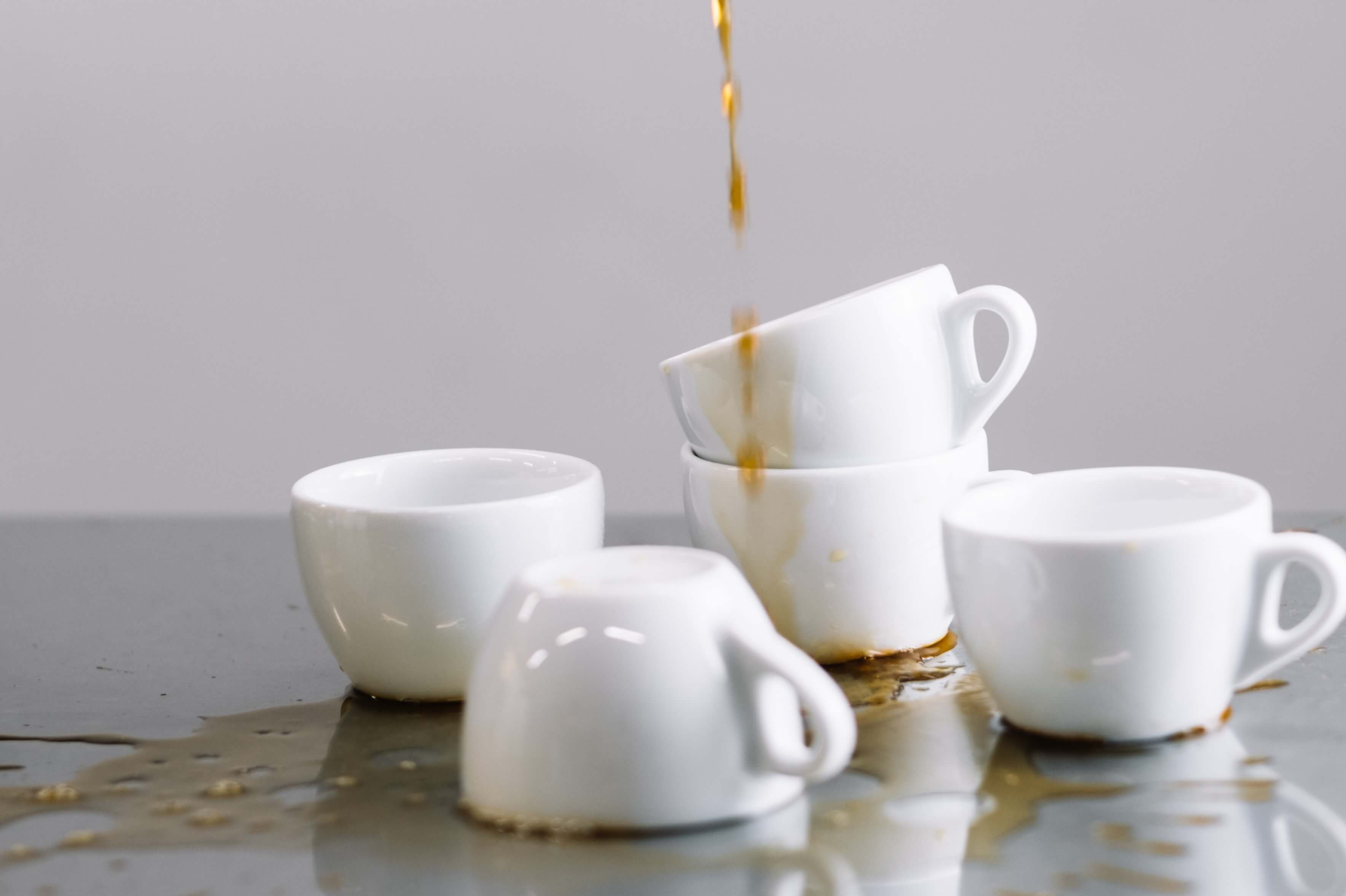 Кофе капает сверху на чашки